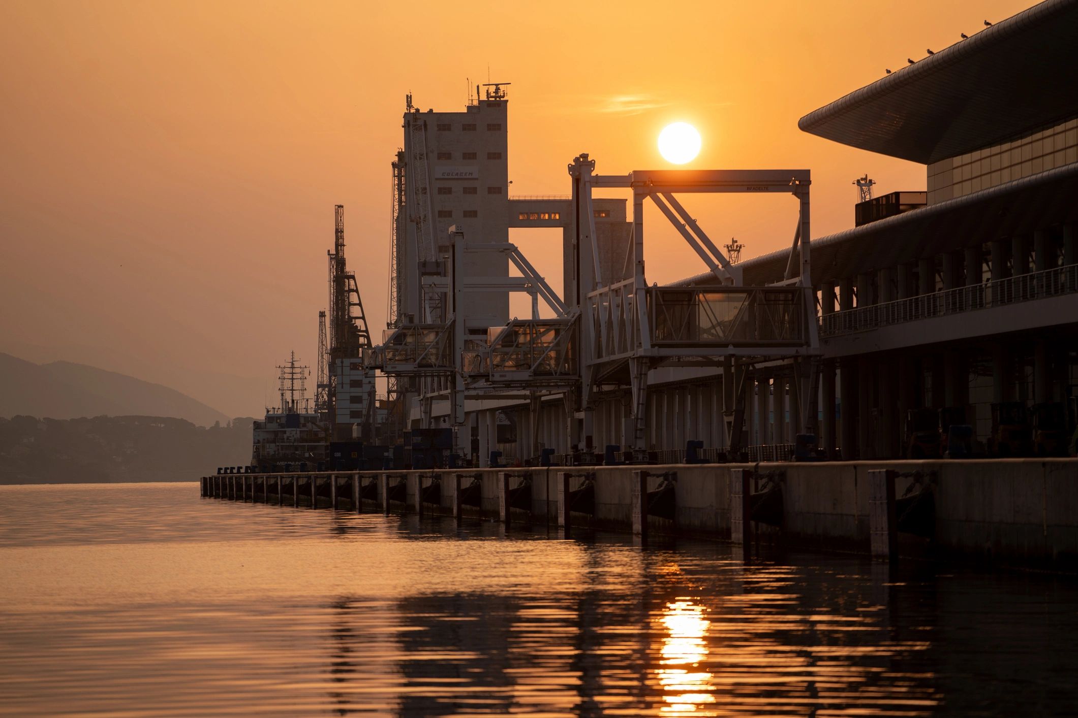 Industrial and passenger port at sunrise representing global trade